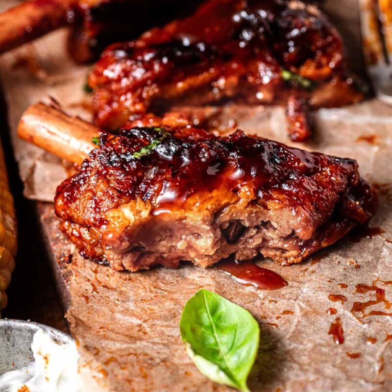 vegan ribs on parchment paper with bbq sauce.