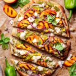 grilled flatbread pizza topped with peaches, basil, hatch chiles and mozzarella.