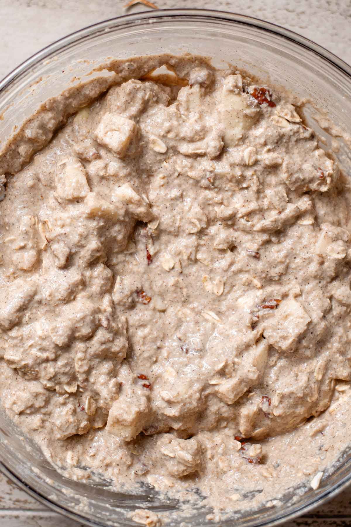 the mixed healthy apple oat cake batter in a glass bowl.