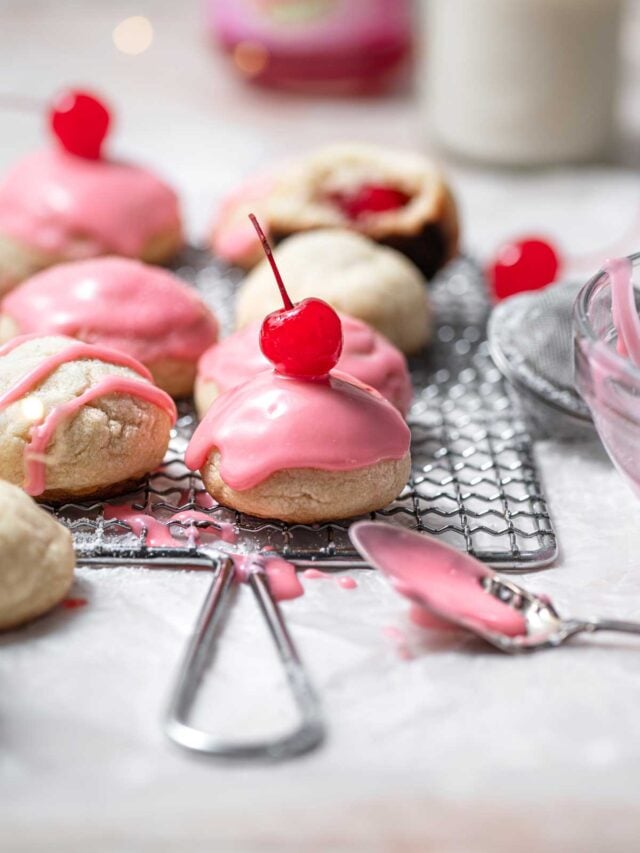 old fashioned cherry bonbon cookies with cherry icing on a cooling rack.