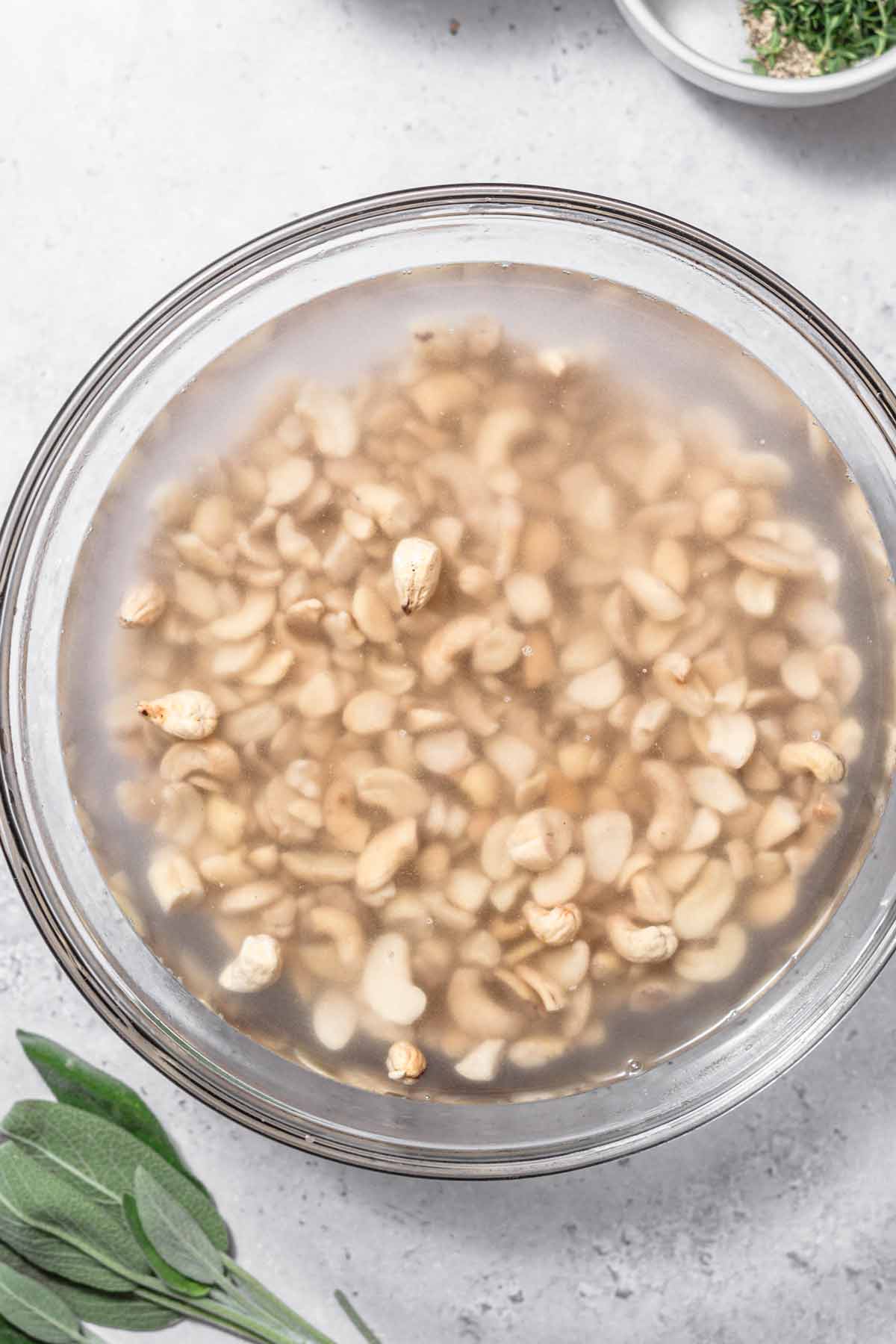 raw cashews being soaked in a bowl.