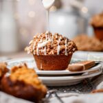 vegan sweet potato muffin with a pecan crumble on top on a plate.