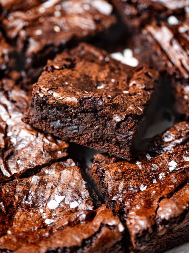 a slice of the best fudgy vegan brownies with shiny, crackly tops.