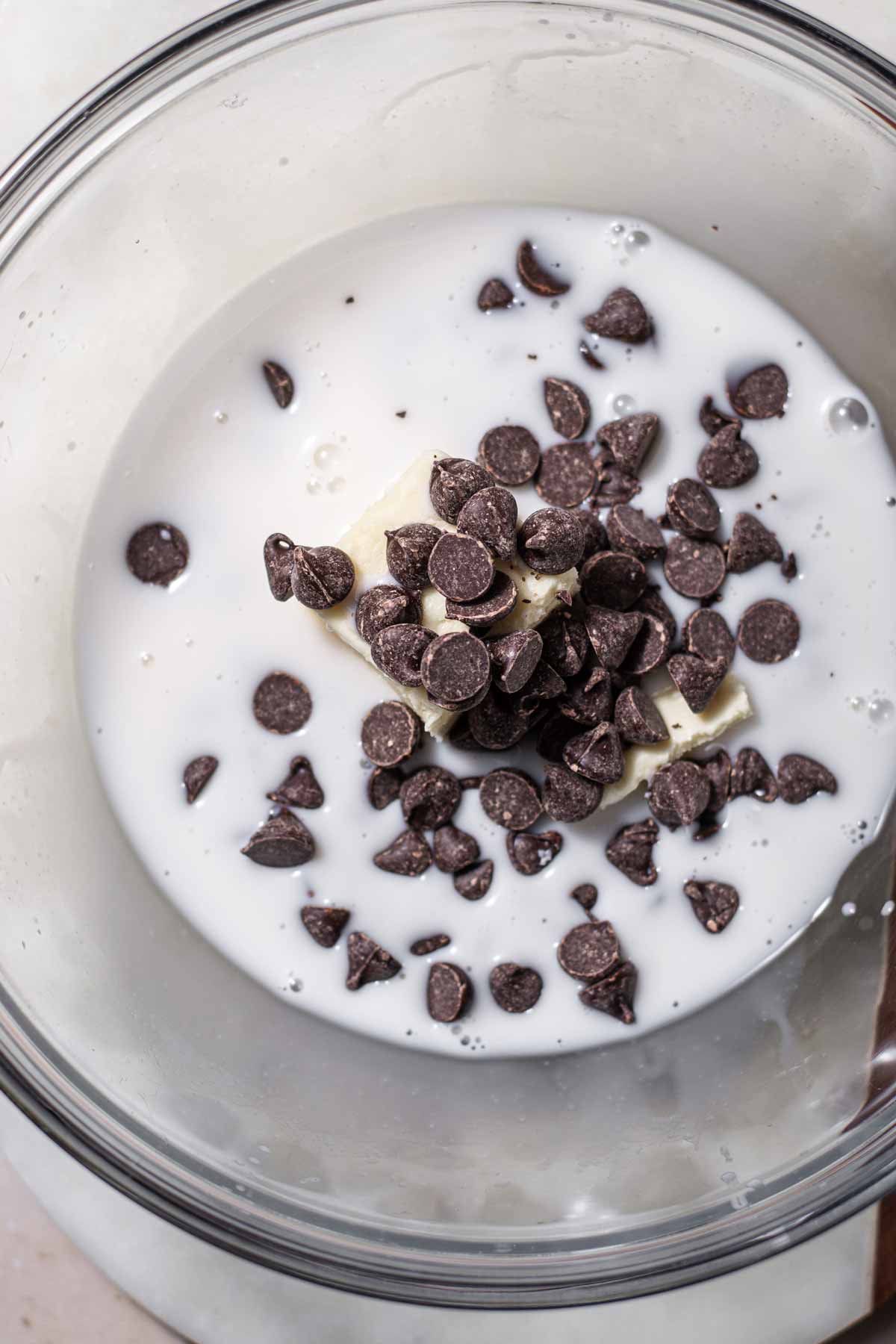 almond milk, vegan butter and chocolate chips in a glass bowl.