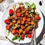A plate of marinated balsamic tofu with fresh basil.