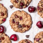 vegan chocolate cherry oatmeal cookie on crumbled white parchment paper.