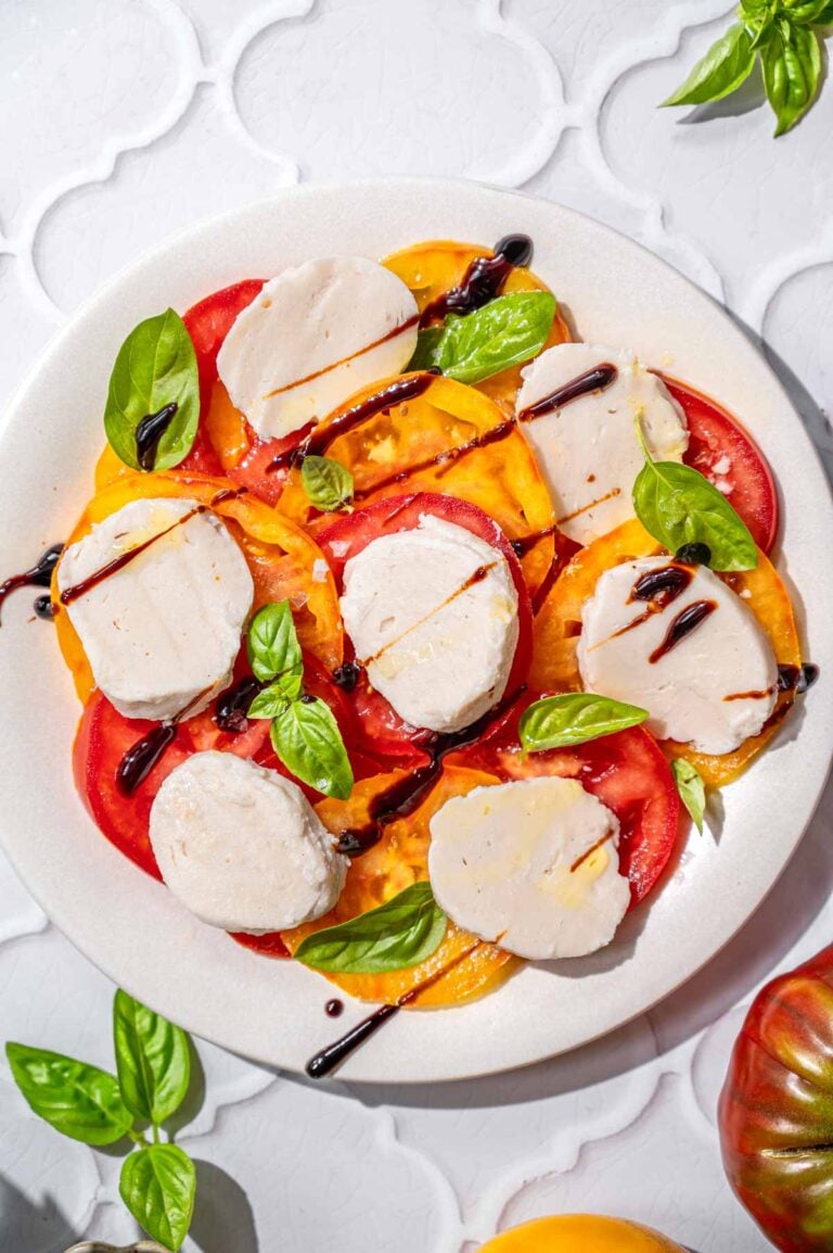 a top view of a vegan caprese salad with heirloom tomatoes.