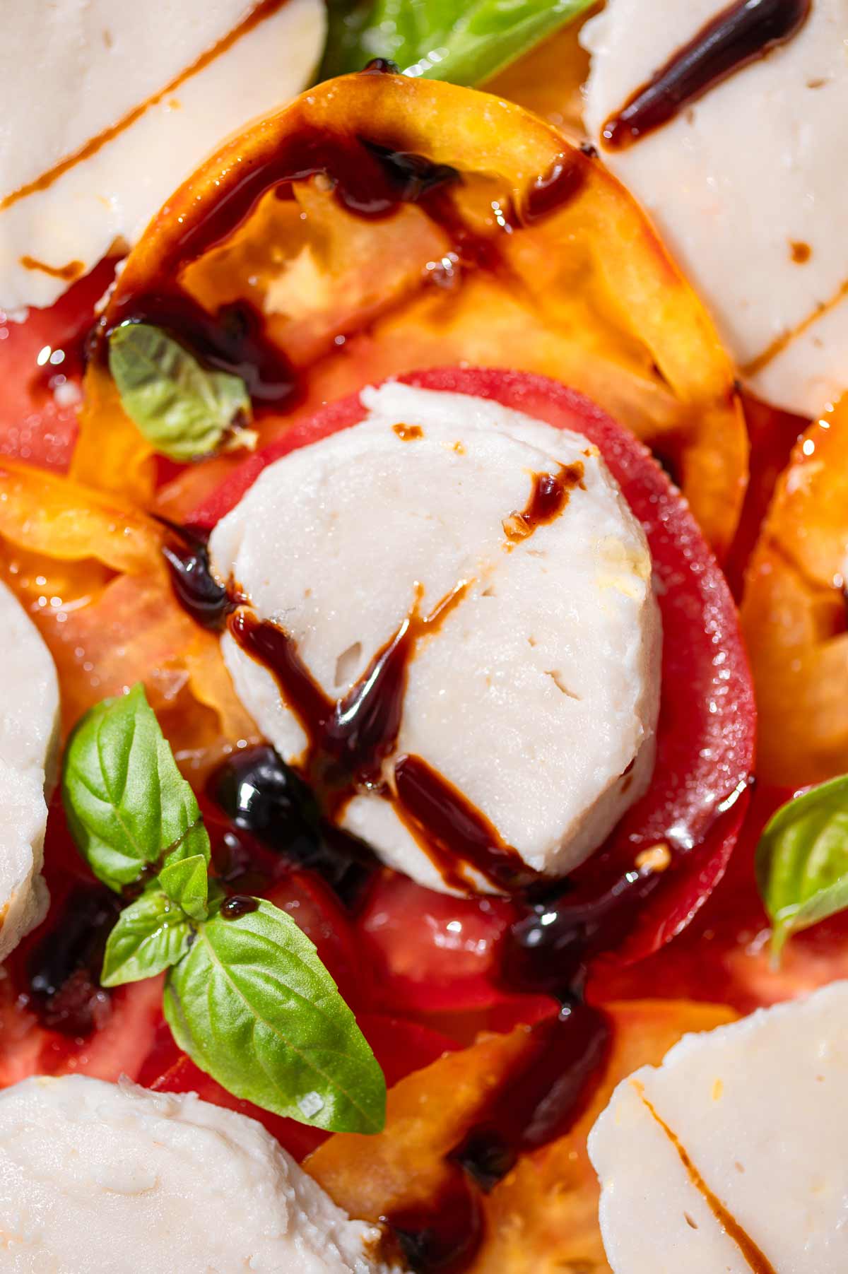 a close up image of dairy-free mozzarella in a vegan caprese.