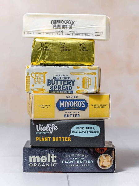 a stack of various plant-based butter packages.