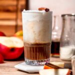 a tall glass filled with a homemade apple crisp cream chai latte.