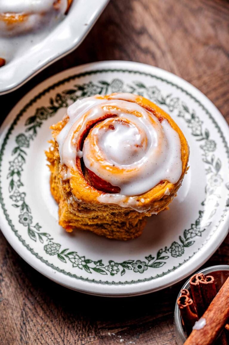 a vegan pumpkin cinnamon roll on a dessert plate.