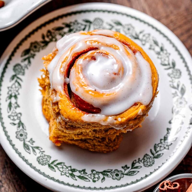 a vegan pumpkin cinnamon roll on a dessert plate.