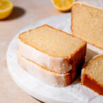 two thick slices of vegan lemon loaf on a marble tray.