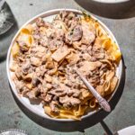 a plate of creamy vegan beef stroganoff with a silver fork.