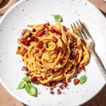 vegan carbonara without eggs on a plate with tofu bacon bits.
