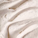 a close up image of the texture of vegan cream cheese frosting.