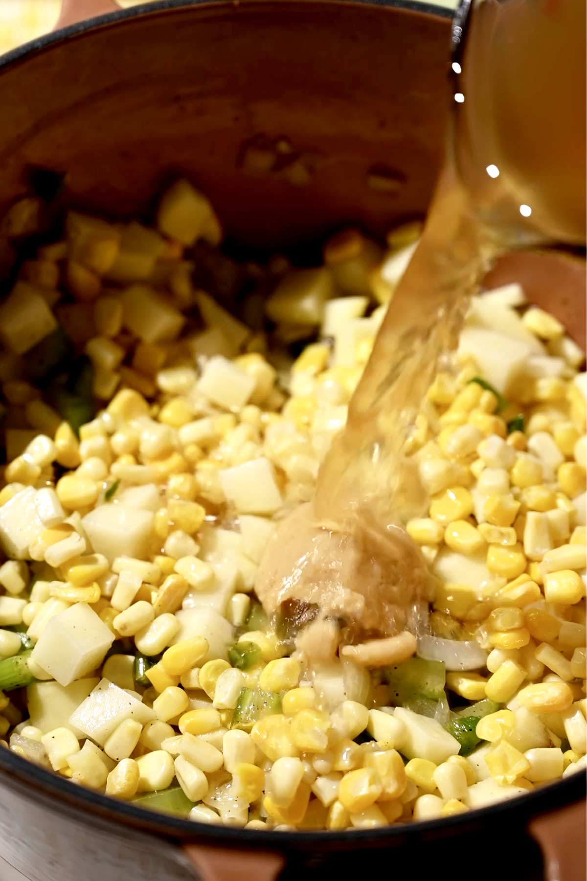miso and vegetable broth being poured on the dutch oven.