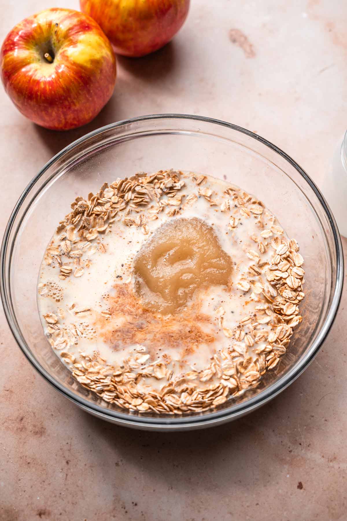 wet ingredients like dairy free soy milk and applesauce in a bowl with the oats.