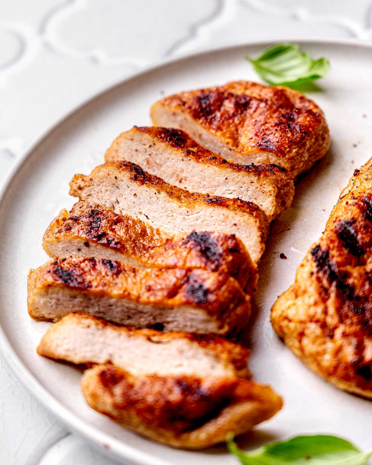 baked vegan chicken breast sliced on a plate.