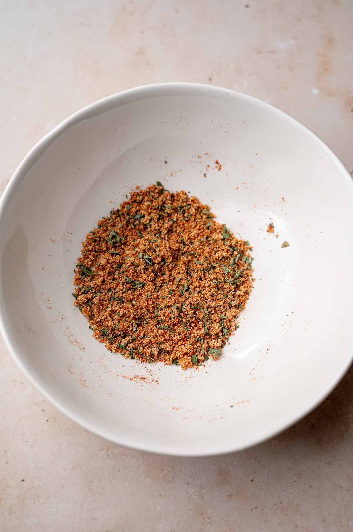 a spice rub in a white bowl.