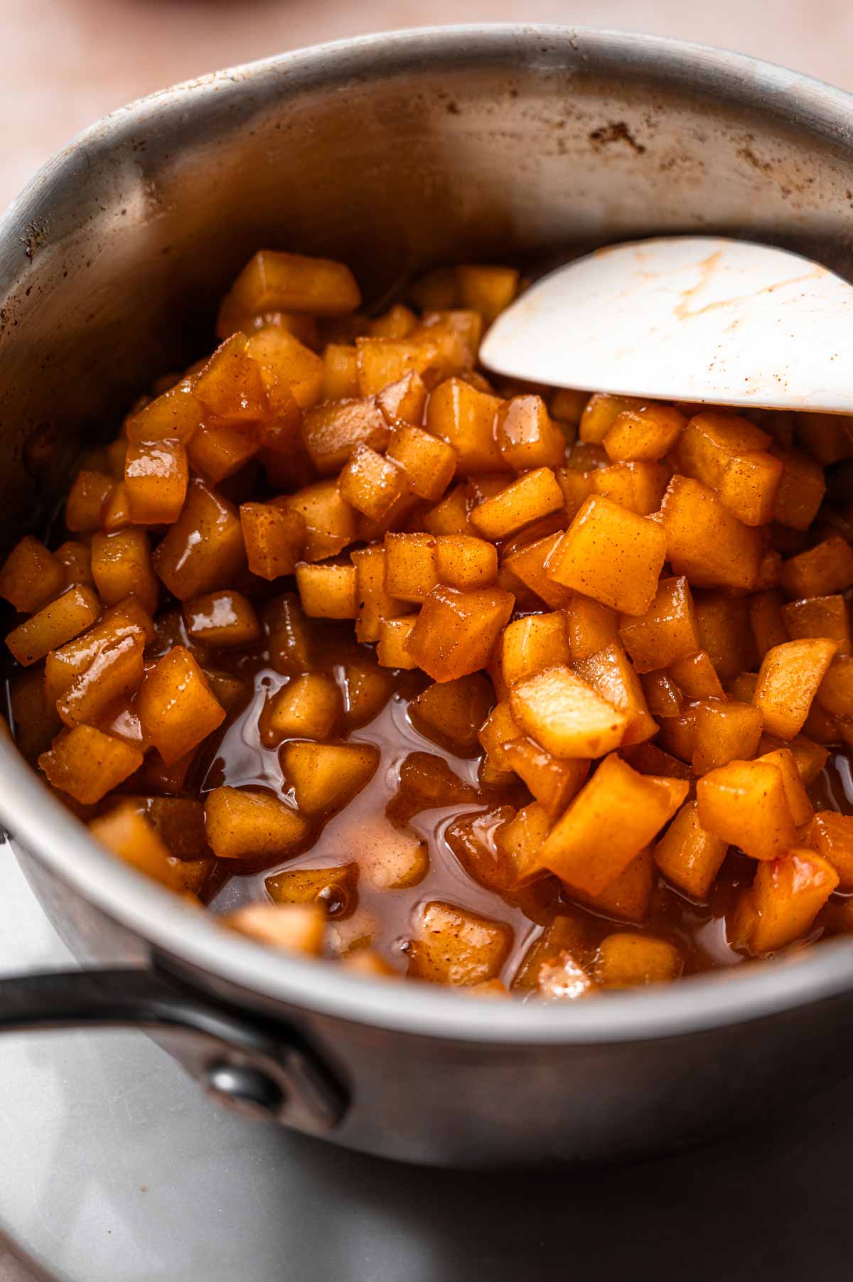 a stainless steel pot with cooked cinnamon apples.