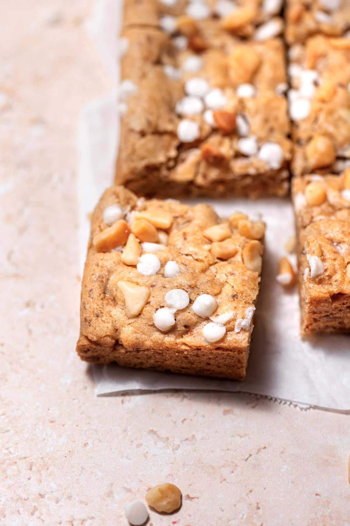 a baked vegan blondie topped with dairy free white chocolate chips.