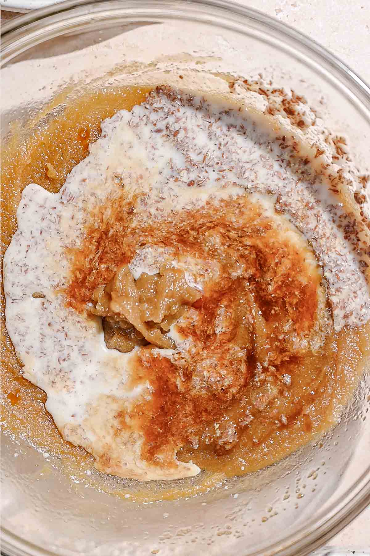 almond milk, ground flaxseed and vanilla added to butter and sugar in a bowl.
