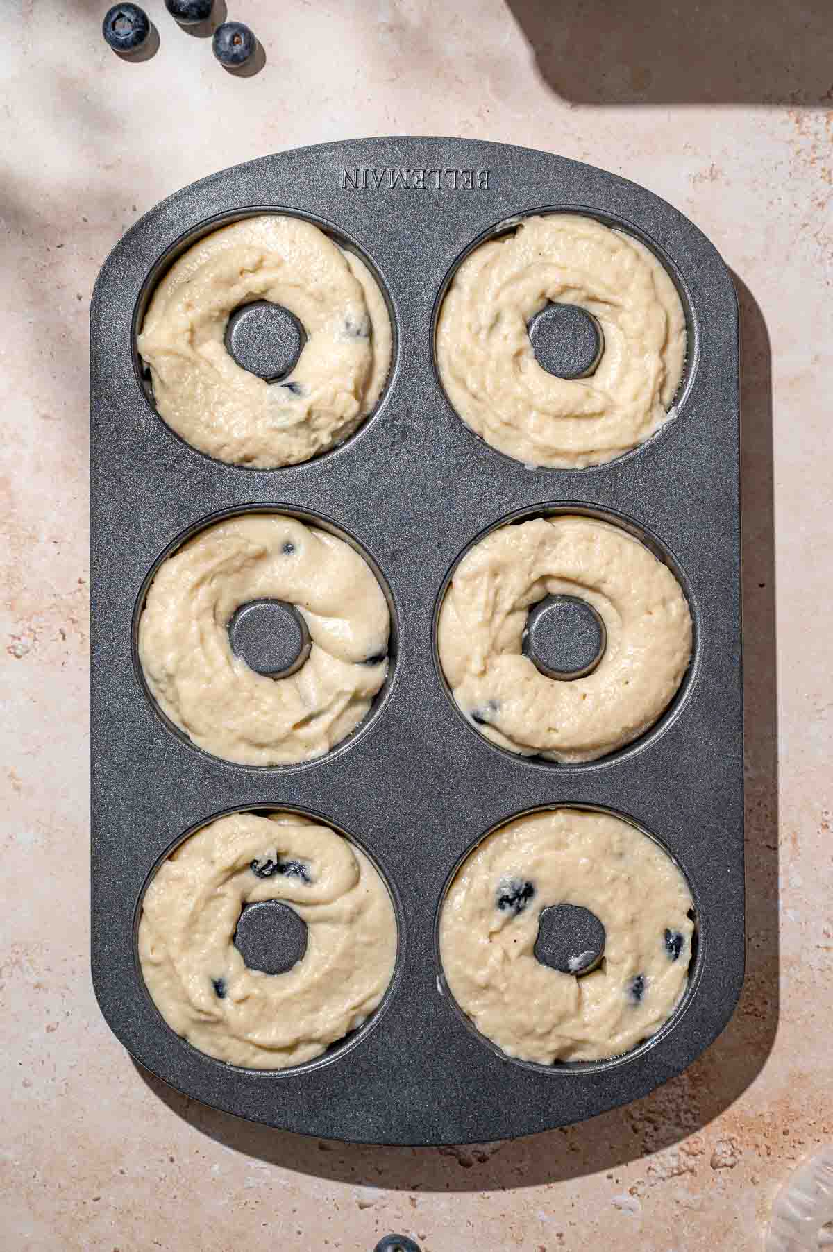 the blueberry donut batter in a donut pan.