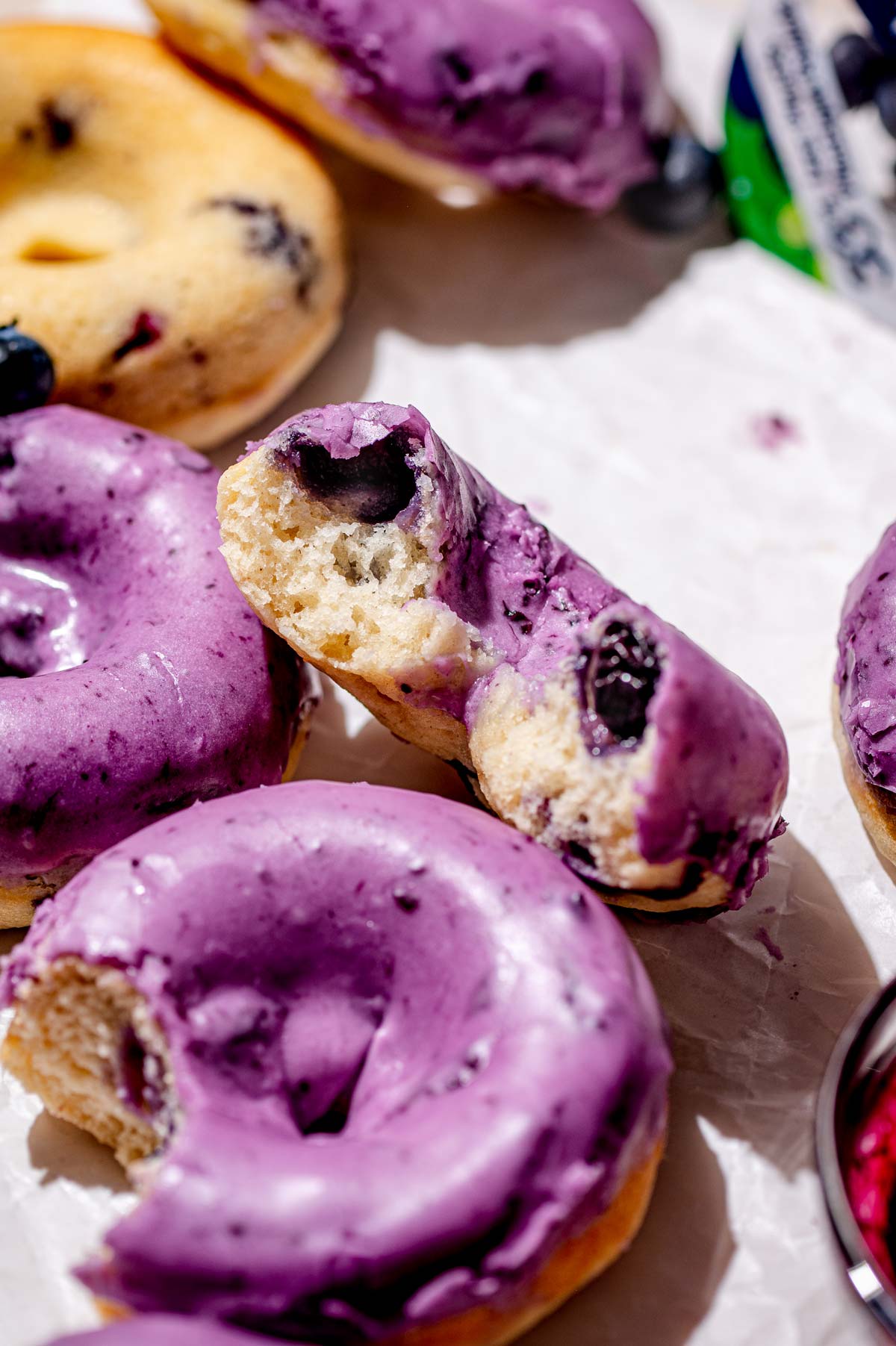 close up image of the inside of a soft blueberry cake donuts with blueberry icing.
