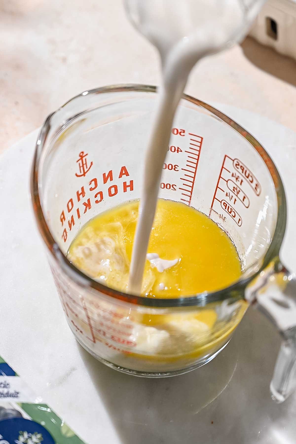 mixing wet ingredients in a glass mixing cup.