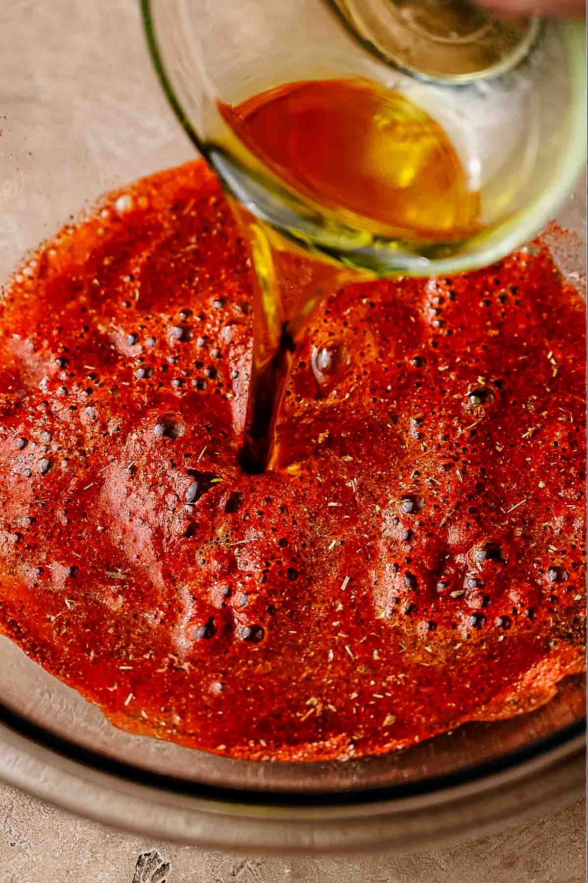 vegetable broth and oil poured into a glass bowl with spices.