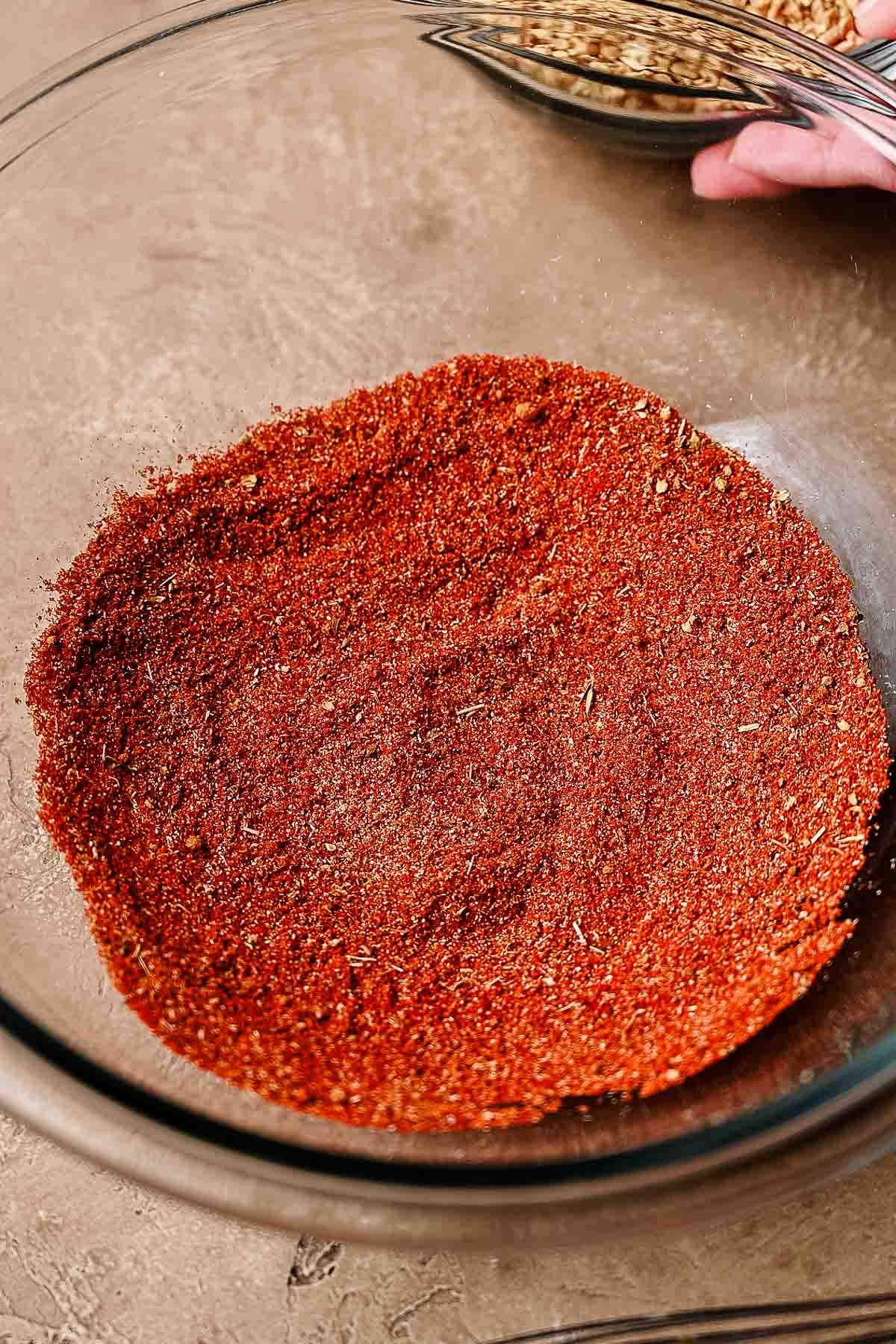 spices like paprika, garlic powder, cayenne and more in a glass bowl.