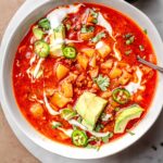a top view of vegan potato chorizo stew topped with avocado.