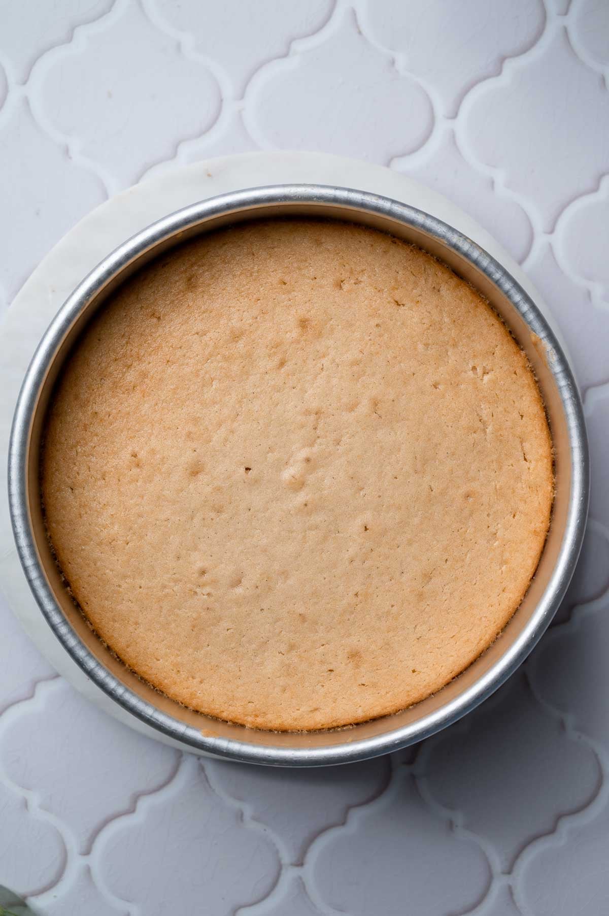 the baked vegan vanilla cake in a round pan.