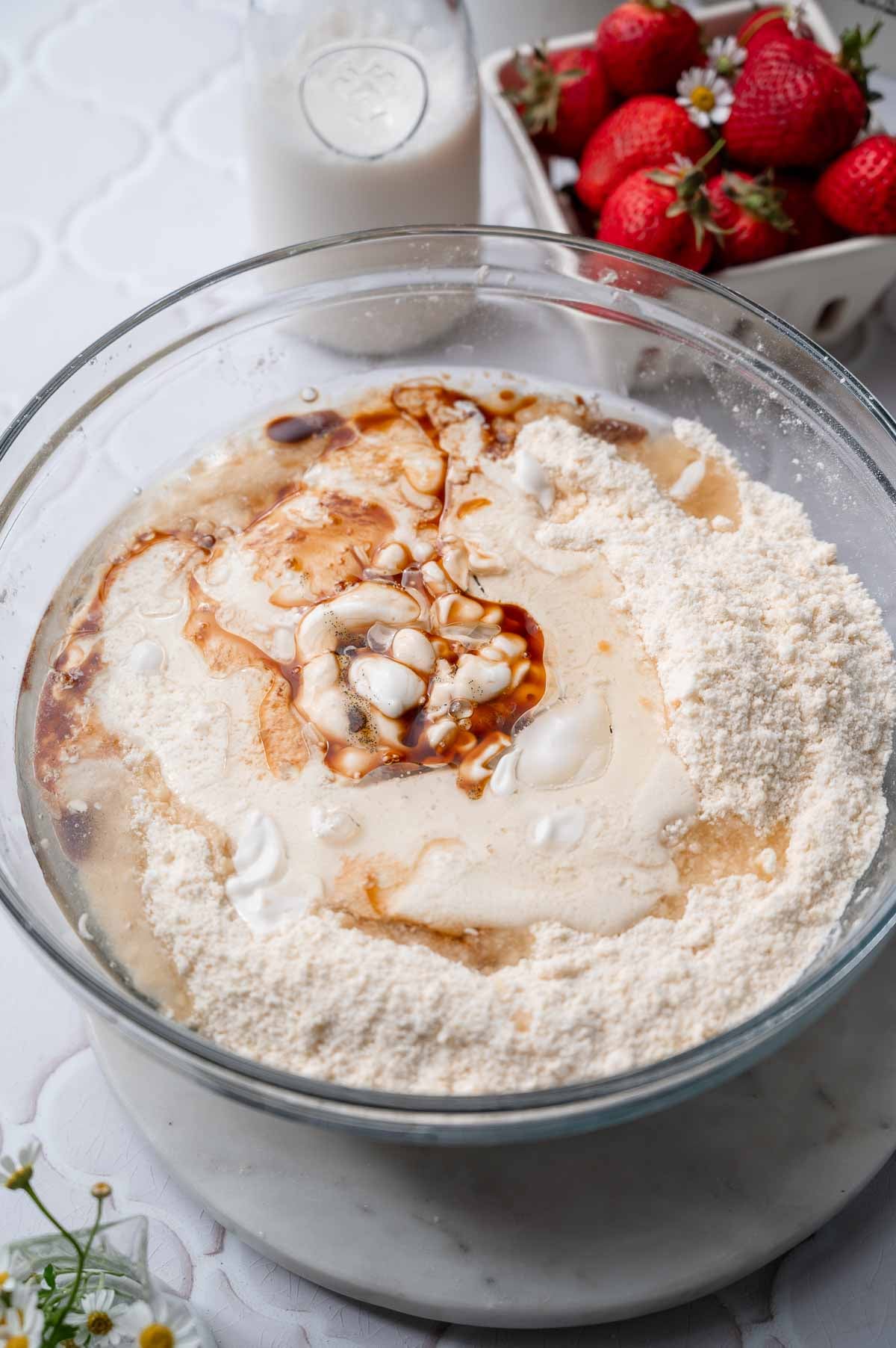 Wet ingredients like oil and yogurt in a bowl with flour for the cake.