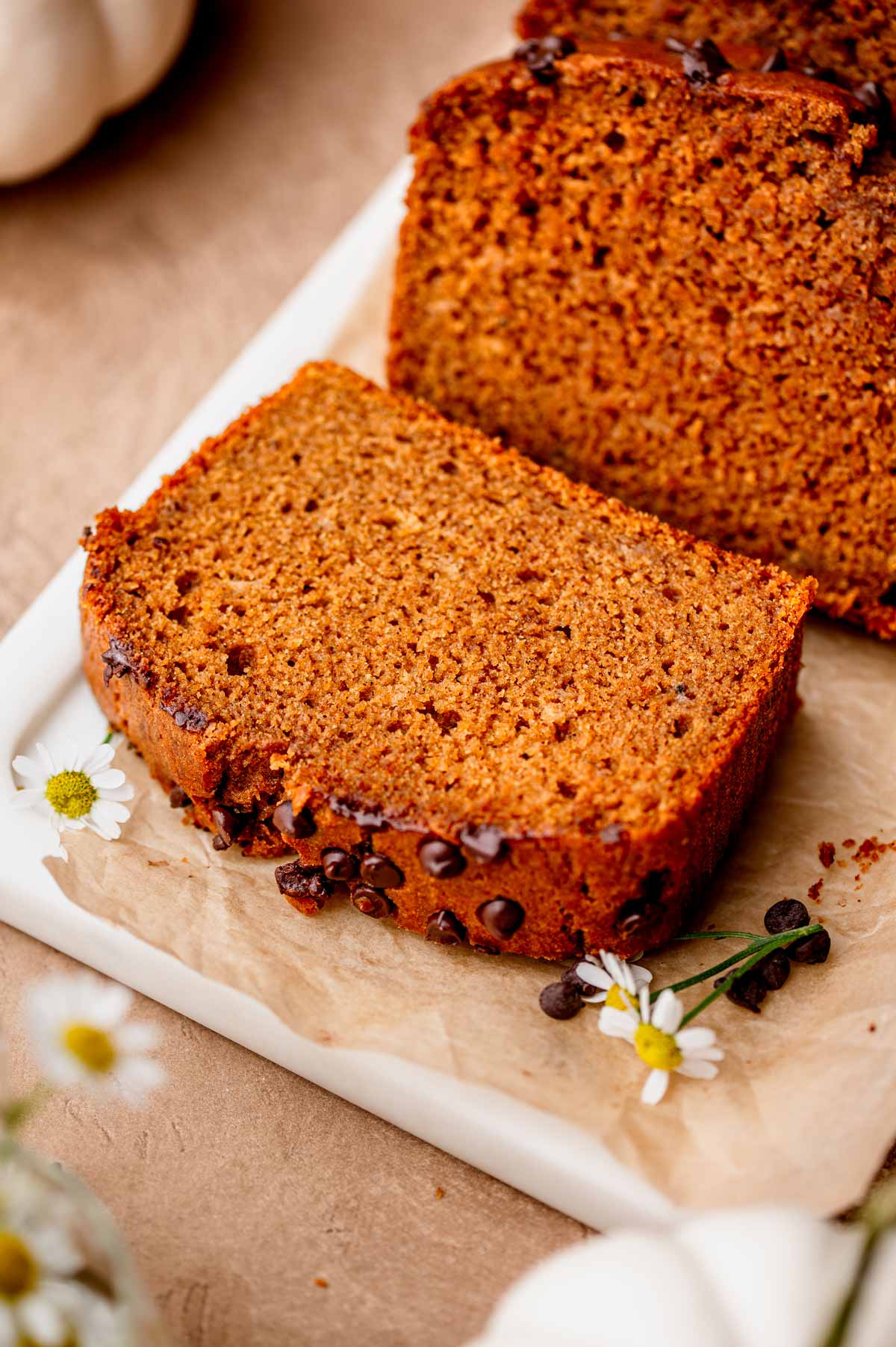 a thick slice of vegan pumpkin banana bread on a marble tray.