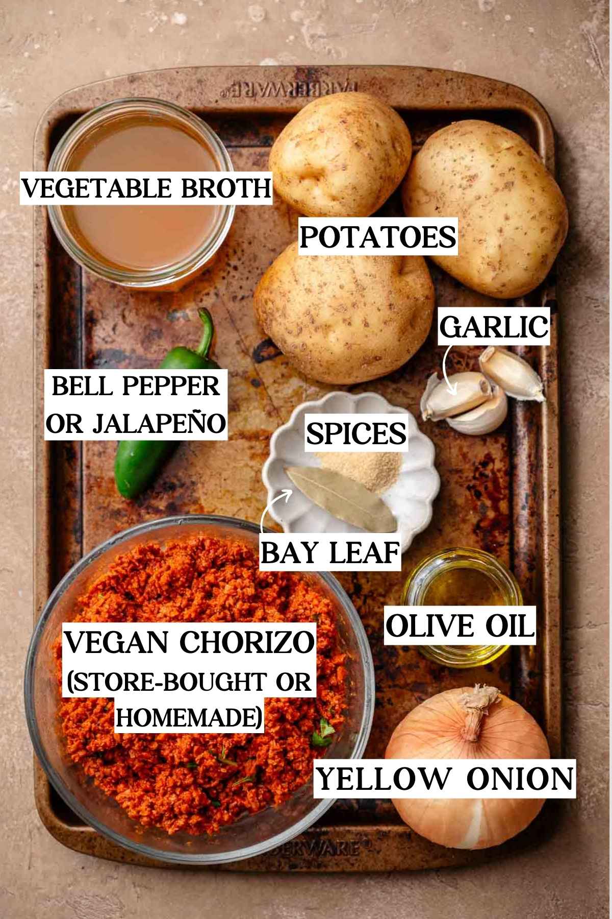 potatoes, vegan chorizo, onion and spices on a metal baking tray.
