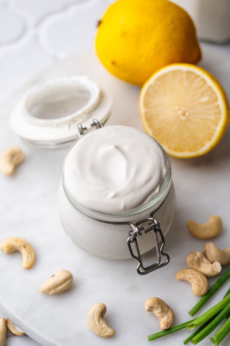 a small jar of vegan cashew sour cream with lemon in the background.