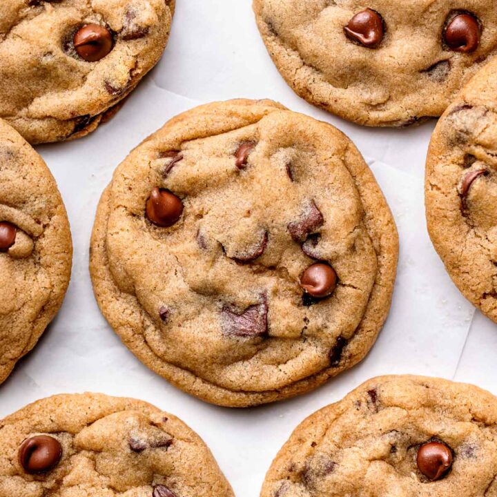 Close-up of freshly baked vegan chocolate chip cookies showing gooey melted chocolate and soft, chewy texture.
