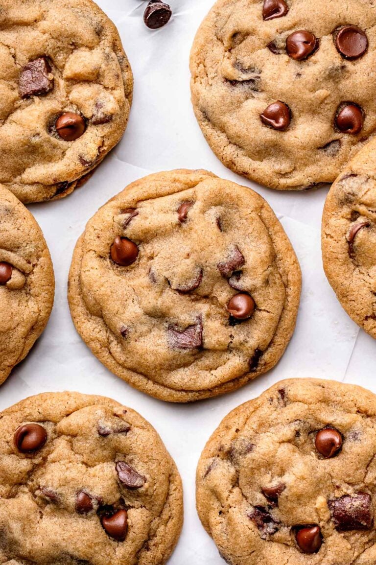 Close-up of freshly baked vegan chocolate chip cookies showing gooey melted chocolate and soft, chewy texture.