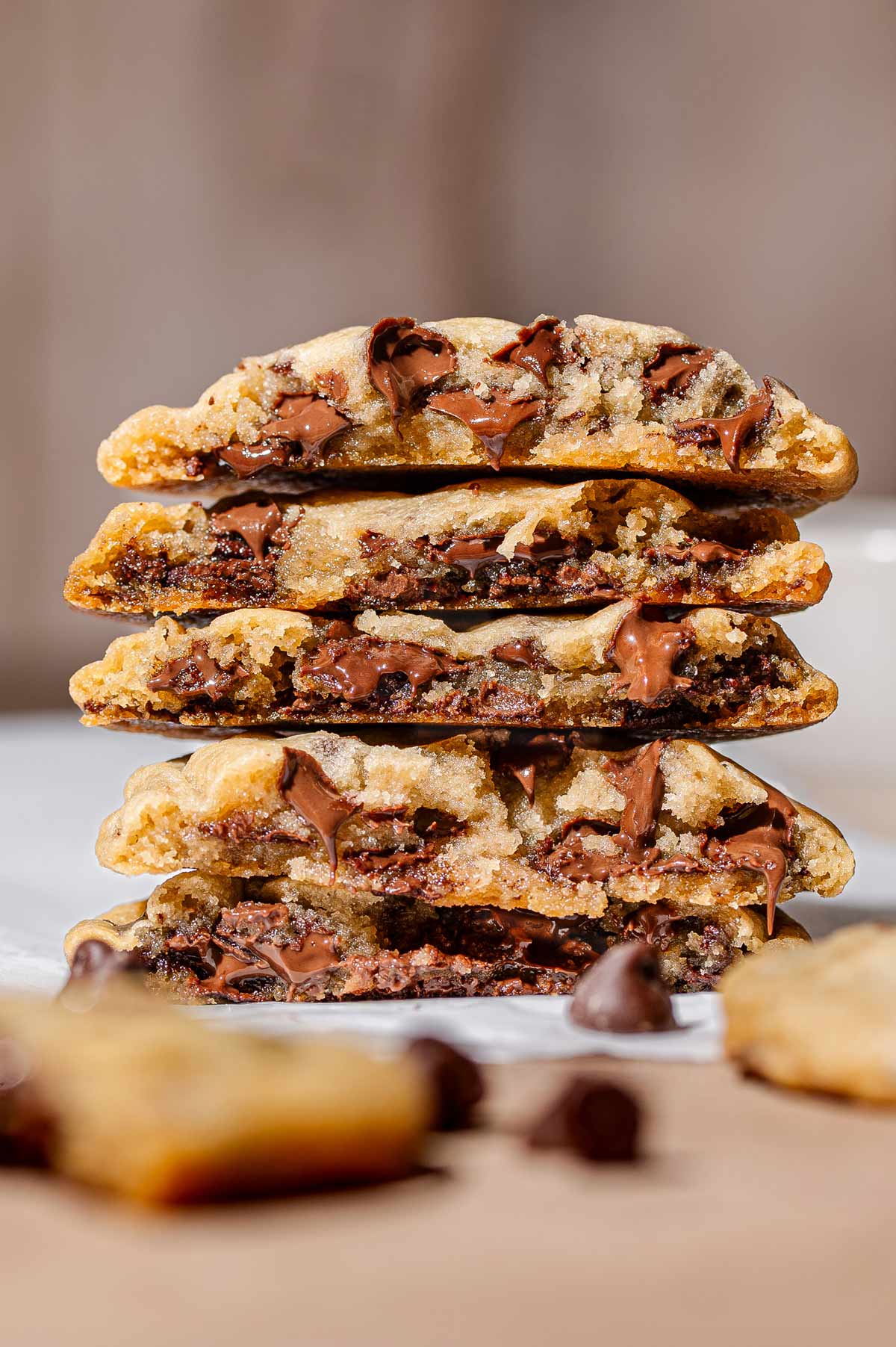 a stack of just baked chewy vegan chocolate chip cookies with gooey melted chocolate.