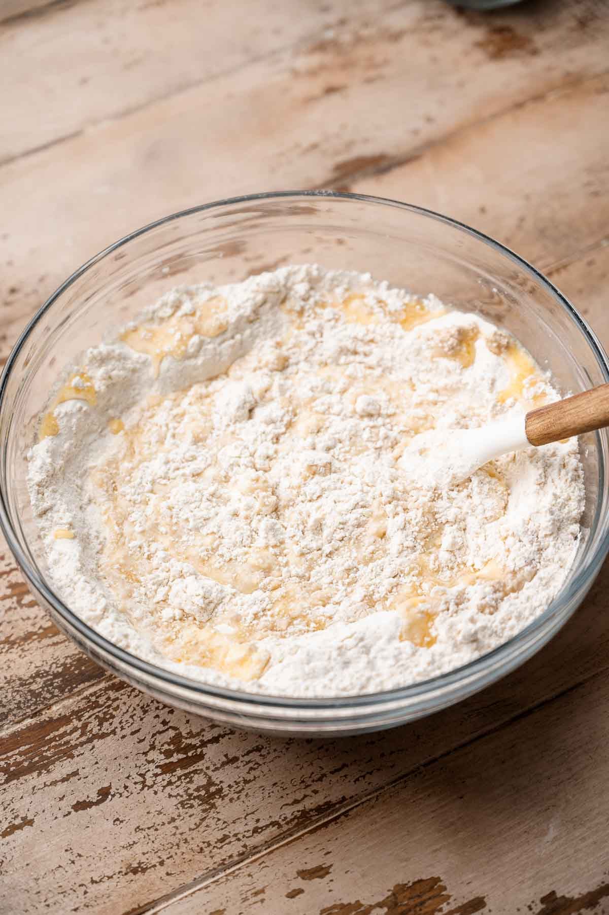 the flour and wet ingredients like oat milk and melted vegan butter in a glass bowl.