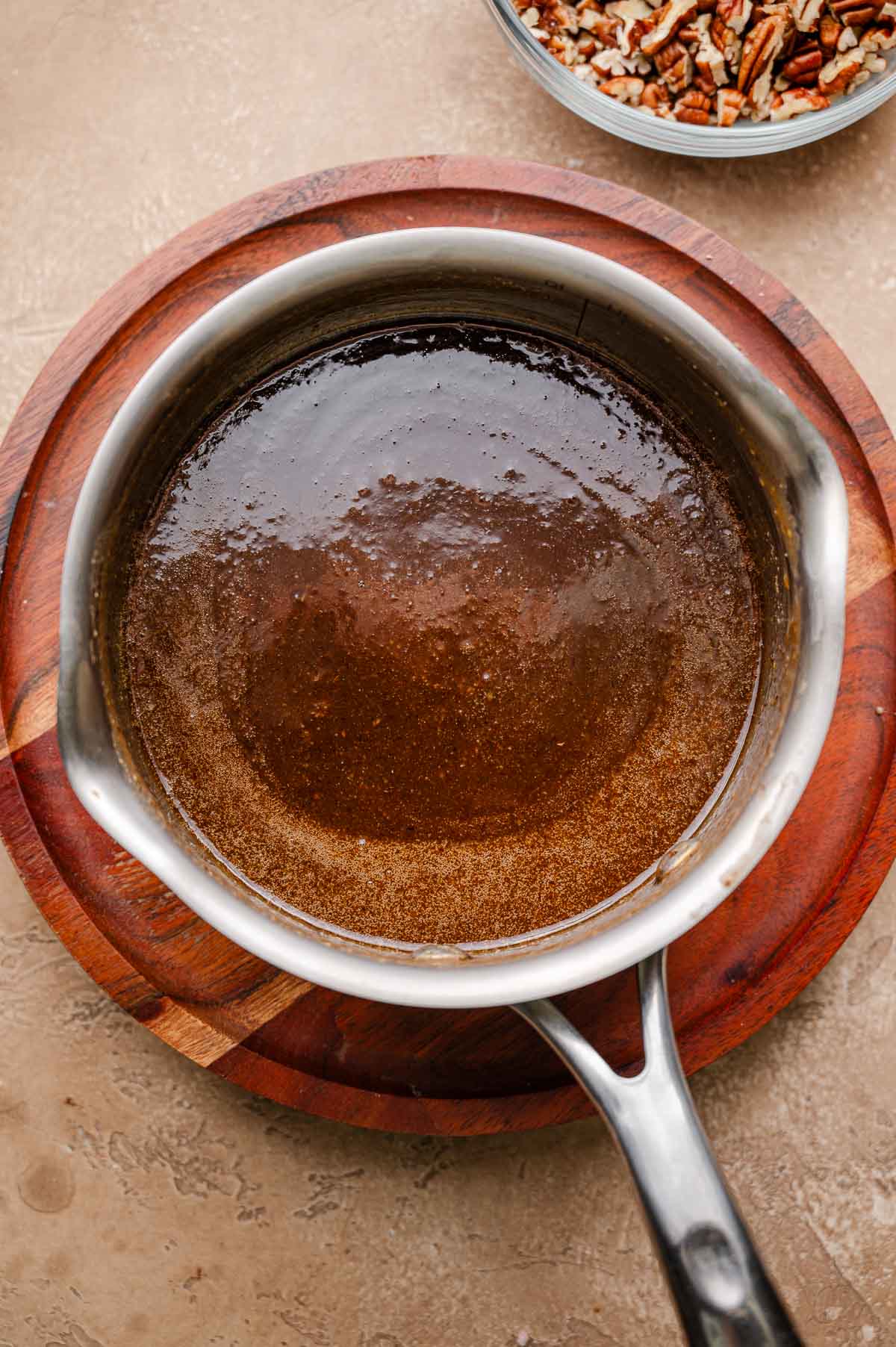 A pot of simmered vegan pecan pie custard before adding the pecans, showing a smooth, thickened caramel mixture.