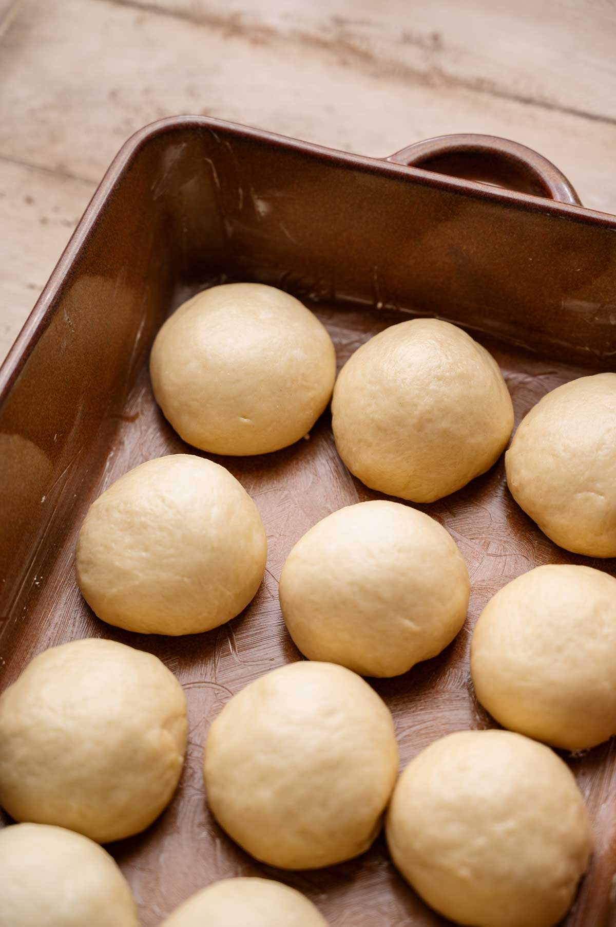 a baking pan with the shaped unbaked vegan rolls.