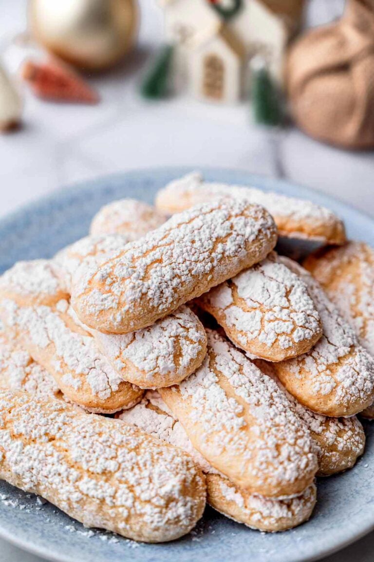 close-up of vegan ladyfinger cookies with cracked tops and a powdered sugar coating.