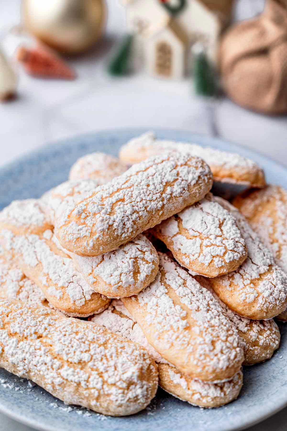 close-up of vegan ladyfinger cookies with cracked tops and a powdered sugar coating.