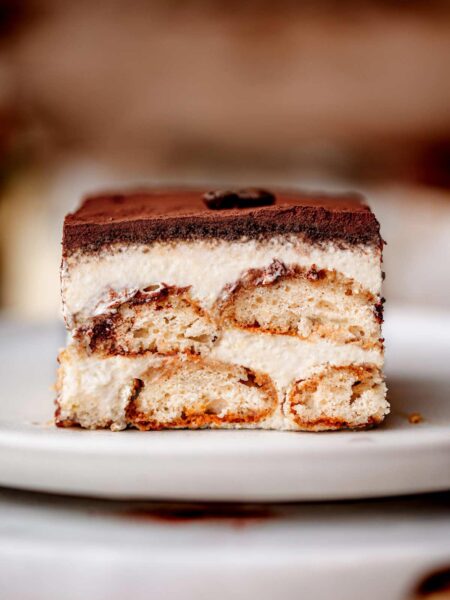 a slice of vegan tiramisu on a ceramic plate.