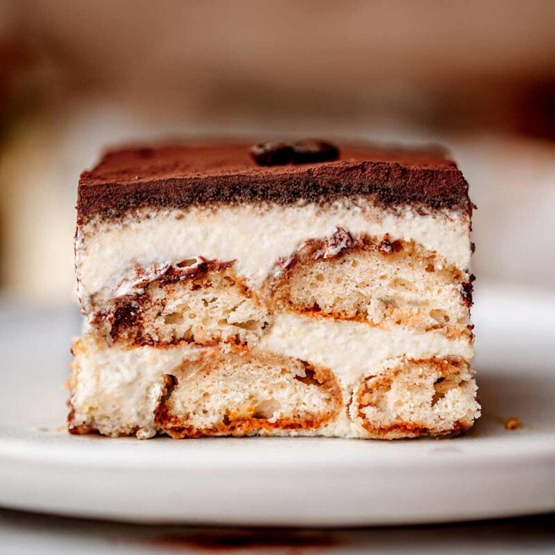a slice of vegan tiramisu on a ceramic plate.