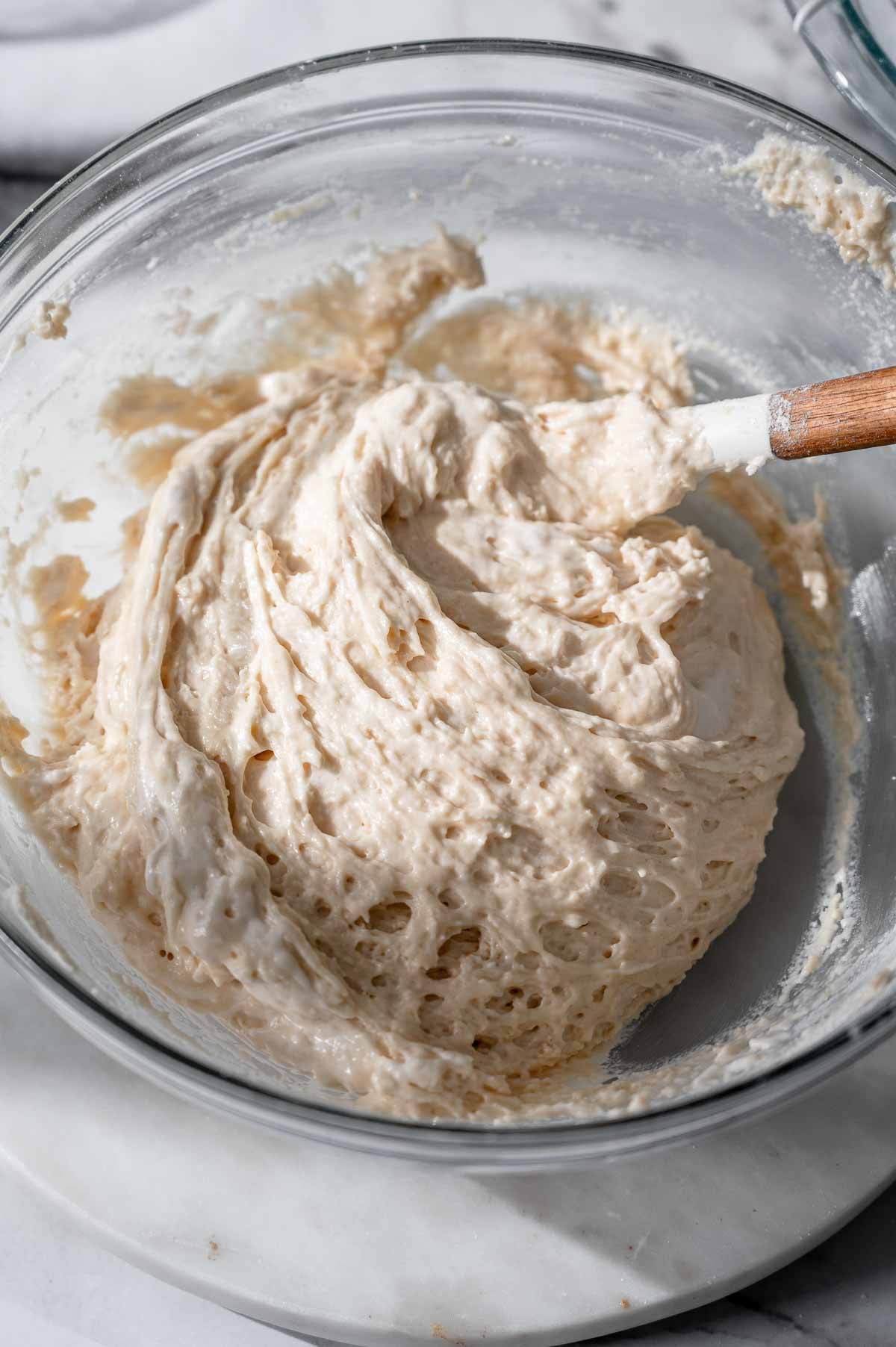 Finished eggless ladyfinger batter with a thick yet airy consistency in a glass bowl.