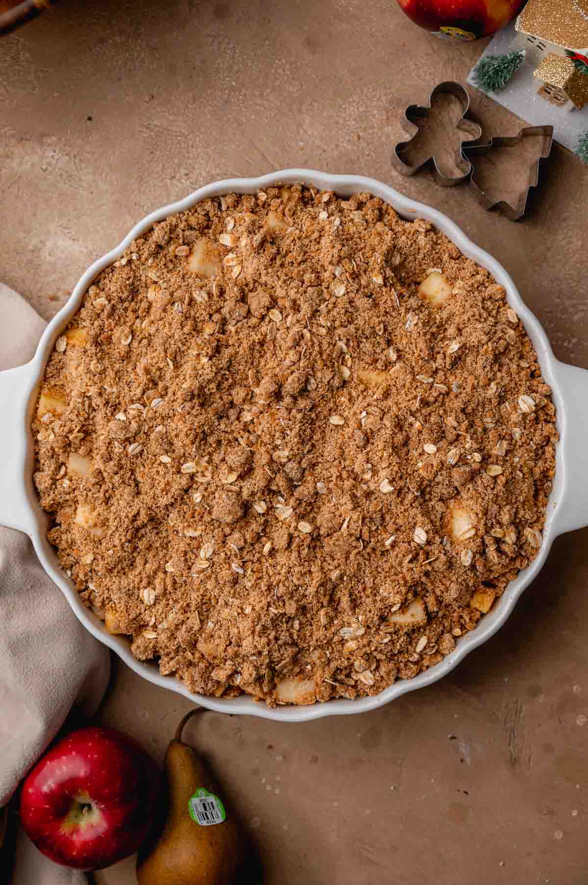 the apples and pears in baking dish topped with a gingerbread crumble.
